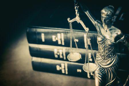 Stacked legal books and lady justice on desk