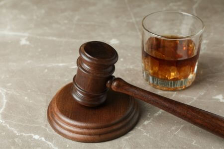 Gavel next to alcoholic drink.